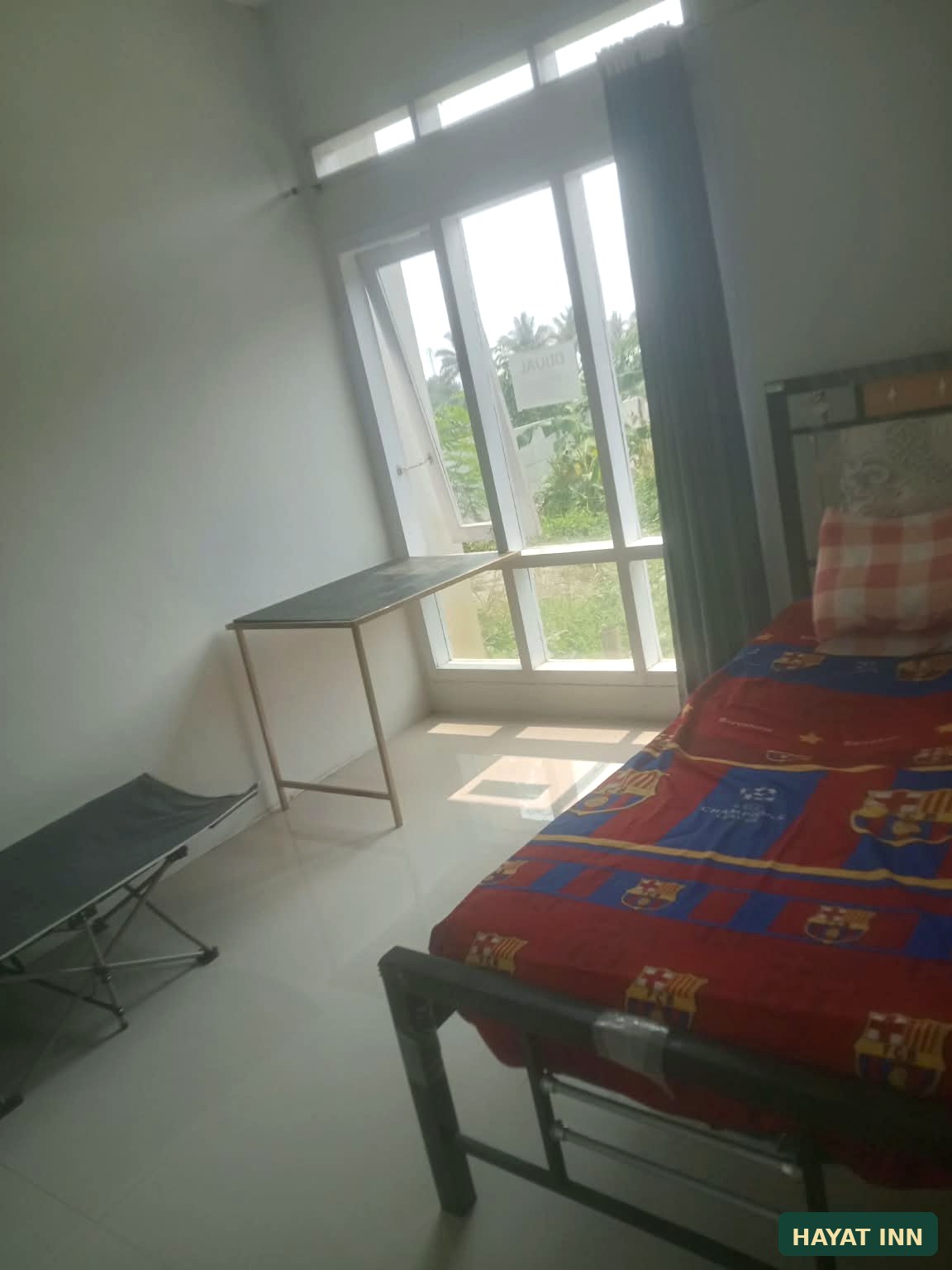 Kamar tidur HAYAT INN dengan jendela besar